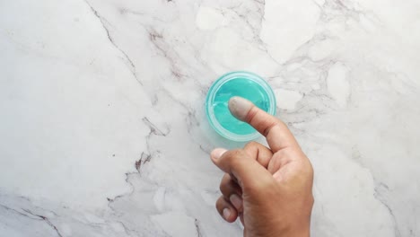 la mano sostiene un frasco de gel para el cabello