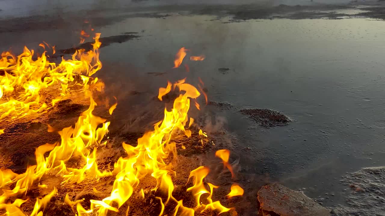 An oil spill slowly burns on the ground melting the surrounding snow
