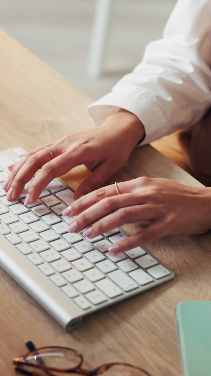 Primo piano di mani che digitano su una tastiera di computer a una scrivania