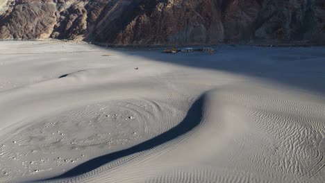 aerial drone shot capturing the vast expanse of nubra valley, with sand dunes, rivers, and mountain ranges.