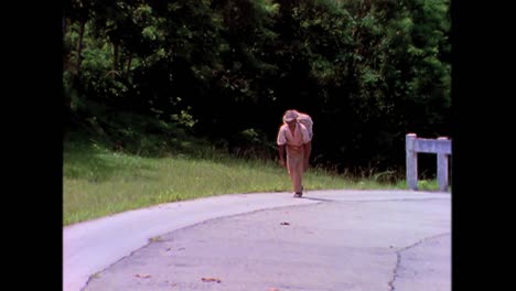 一名老人带着烟草沿着一条道路在 1980 年代