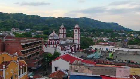 Zoom-Aéreo-Del-Carro-Hacia-La-Catedral-En-La-Ciudad-De-Honda-Colombia,-Montañas-Detrás