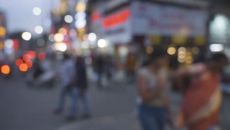 defocused shot of busy street with people and traffic in bangalore india at dusk