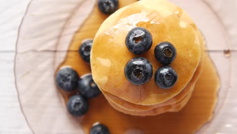 stack of pancakes with blueberries and maple syrup