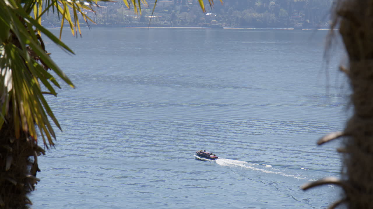 Speedboat Sailing Across The Lake Como On A Sunny Day In Tremezzo, Lombardy, Italy, wide shot
