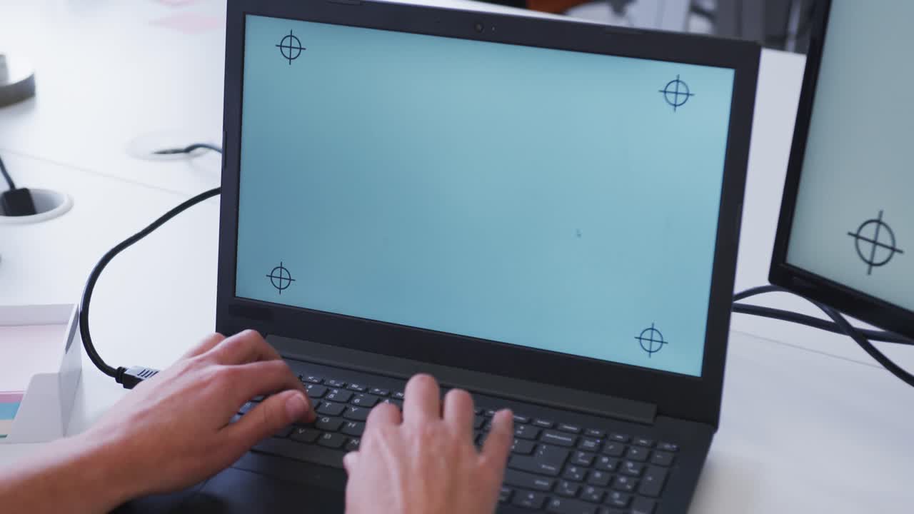 manos de una mujer de negocios caucásica usando una computadora portátil en el escritorio de la oficina