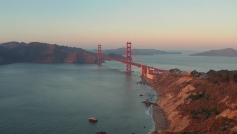 Amplia-Toma-Aérea-Descendente-Del-Puente-Golden-Gate-Al-Atardecer