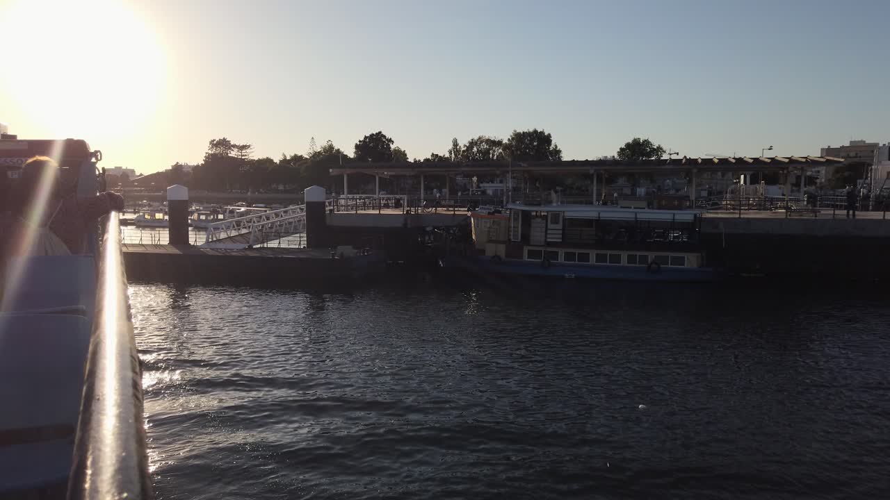 acercándose lentamente al muelle del puerto deportivo de olhao en ferry al atardecer, portugal
