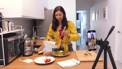 woman cooking and demonstrating a recipe online