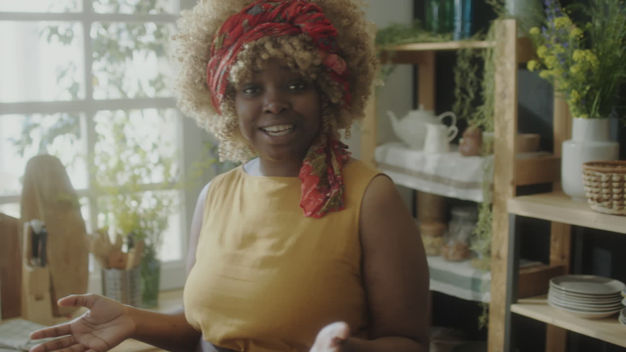 Afroamerická food blogerka mluvící do kamery v kuchyni.
