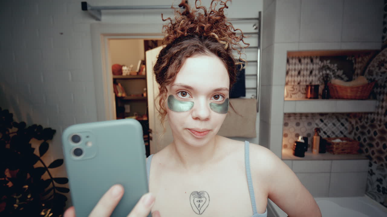 chica de la generación z con parches debajo de los ojos grabándose con el teléfono en el baño