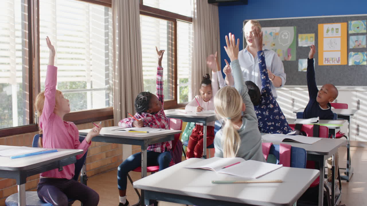 In school, female teacher engaging with students raising hands in classroom discussion
