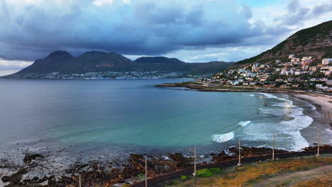 Sudafricano-Amanecer-Puesta-De-Sol-Mañana-Simon&#39;s-Town-Dron-Aéreo-Cinemático-Fish-Hoek-Escabroso-Arrecife-Costa-Pequeño-Pescar-Puerto-Deportivo-Ciudad-Maravilloso-Verano-Primavera-Profundo-Agua-Azul-Océano-Vías-Del-Tren-Espalda-Movimiento