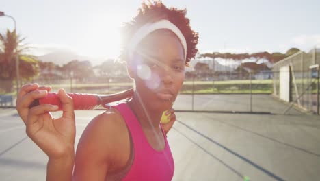 Video-Einer-Afroamerikanischen-Tennisspielerin,-Die-Einen-Schläger-Hält-Und-In-Die-Kamera-Blickt