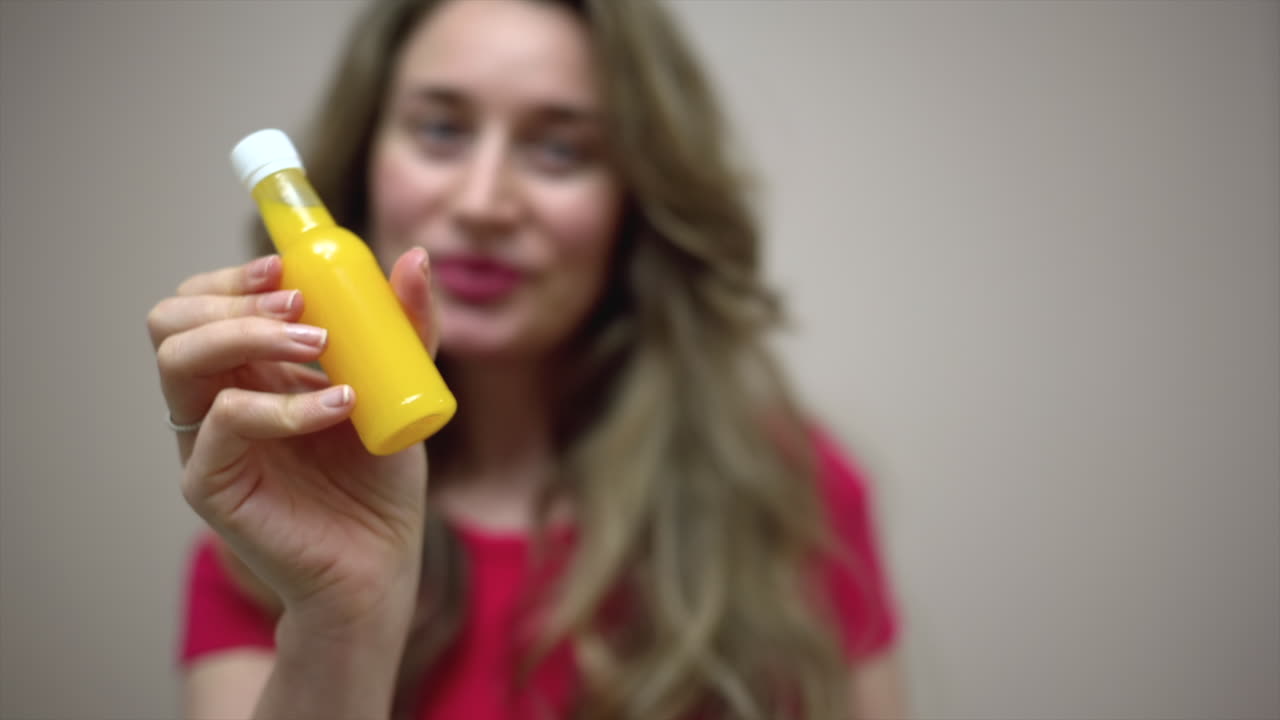 Close up of a brunette woman drinking a ginger shot
