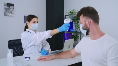 médico comprobando la temperatura y el oxímetro de pulso del paciente