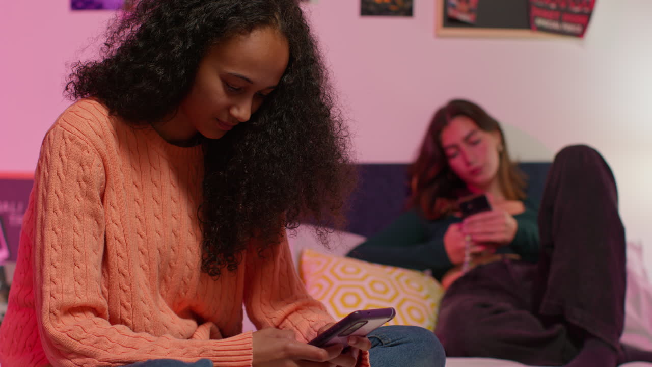 niñas adolescentes usando teléfonos inteligentes en un dormitorio