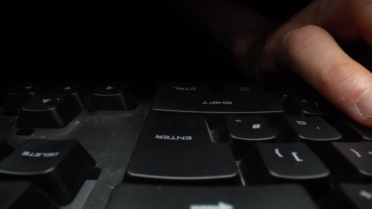 Hands typing on a computer keyboard. Dolly shot. left to right. Macro.