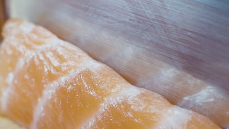 Close-up-of-Raw-Salmon-Being-Sliced-into-Pieces-for-Sushi-and-Sashimi