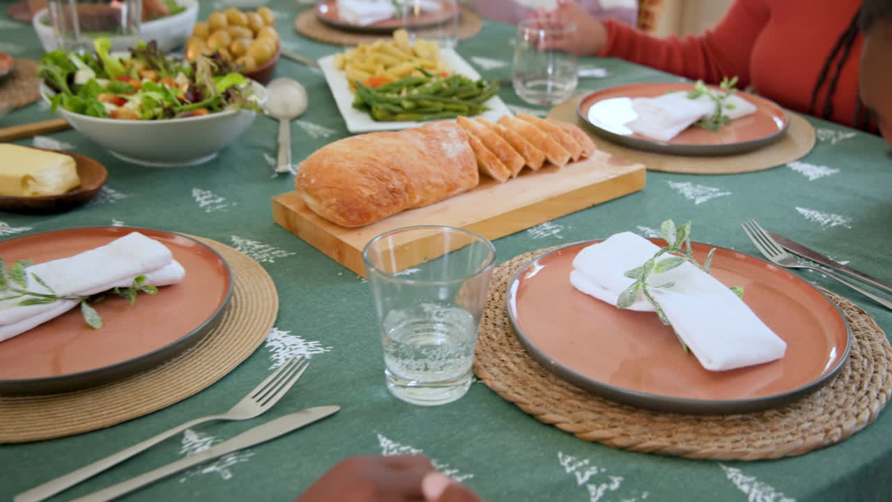 At Christmas, Festive Diverse family gathering around table with fresh bread and colorful salad