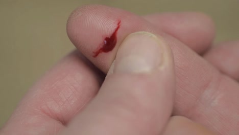 paper cut on finger with drop of blood close up