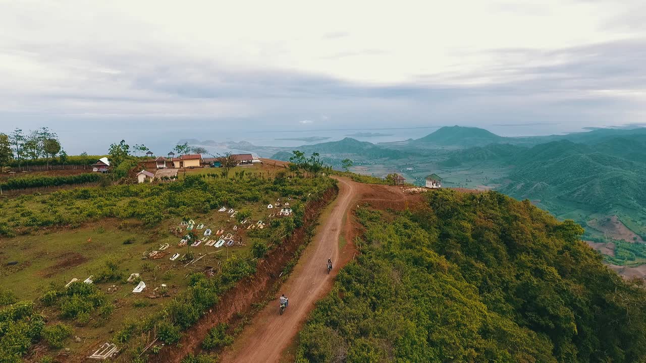 Aerial View of a Scenic Mountain Landscape with a Dirt Road, Cemetery, and Coastal Vistas