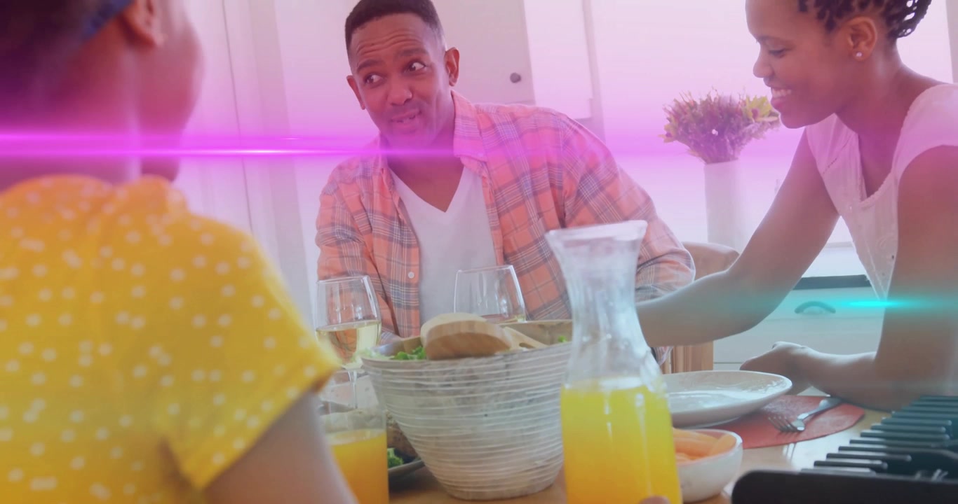 Père se penchant pour entamer une conversation familiale au petit-déjeuner, montrant des icônes de nutrition animées sur du jus d'orange.