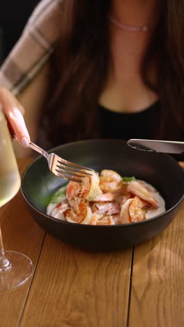 woman eating creamy shrimp pasta