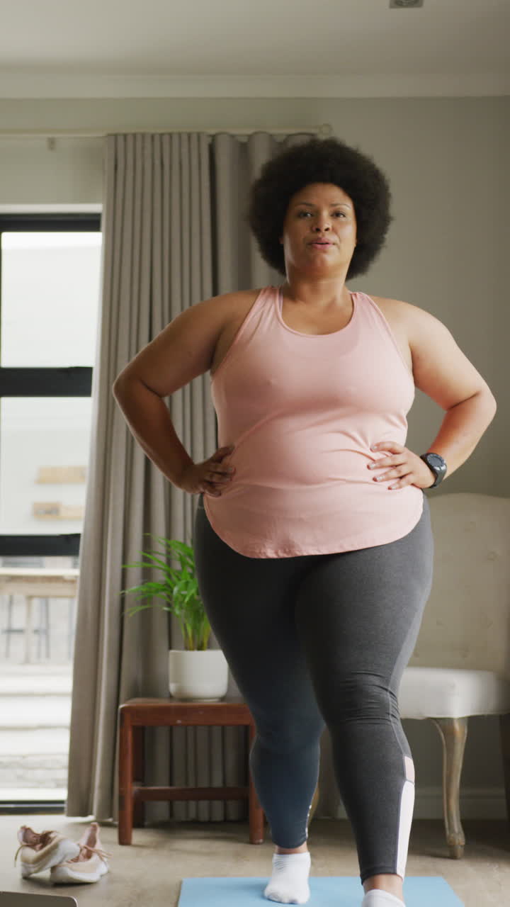 Video verticale di donna birazziale curvy che si allena a casa