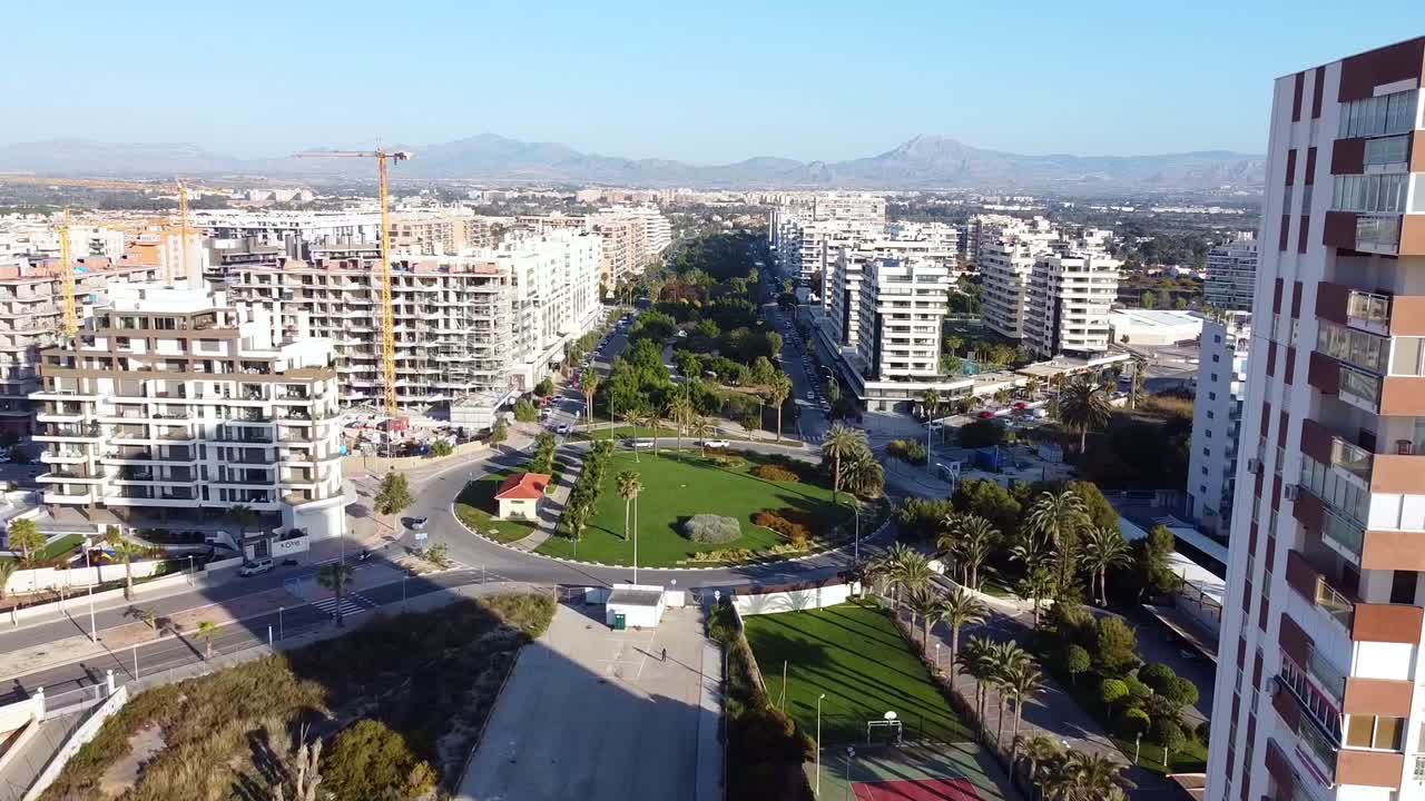 Filmato aereo di nuovi edifici in costruzione in un'area di cantiere vicino alla spiaggia di San Juan, Spagna