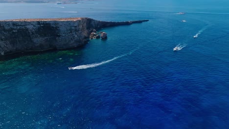 aerial video capturing boats cruising along malta's rugged coastline, showcasing the island's dramatic cliffs and deep blue mediterranean waters