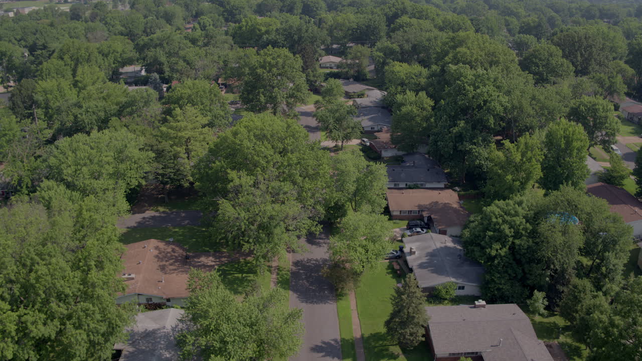 aerial flyover suburbs and streets with cars driving across frame
