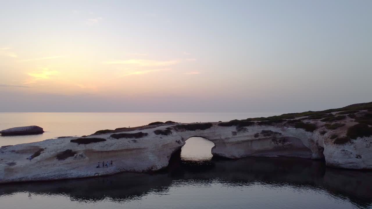 S'Archittu spectacular aerial drone flying towards natural arch, sunset