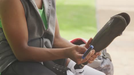 Side-view-man-readjusting-his-prosthetic-leg