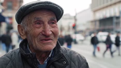 an elderly man smiles warmly as he shares his life experiences. the lively background features pedestrians and city buildings on a cool autumn day, reflecting urban life.