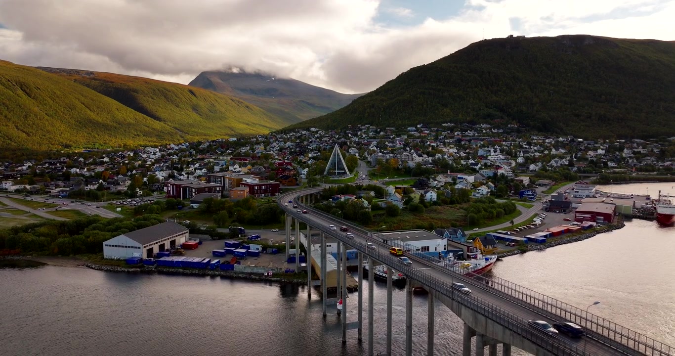 Trafik över Tromsö bro med flygvy över staden och Ishavskatedralen på hösten.