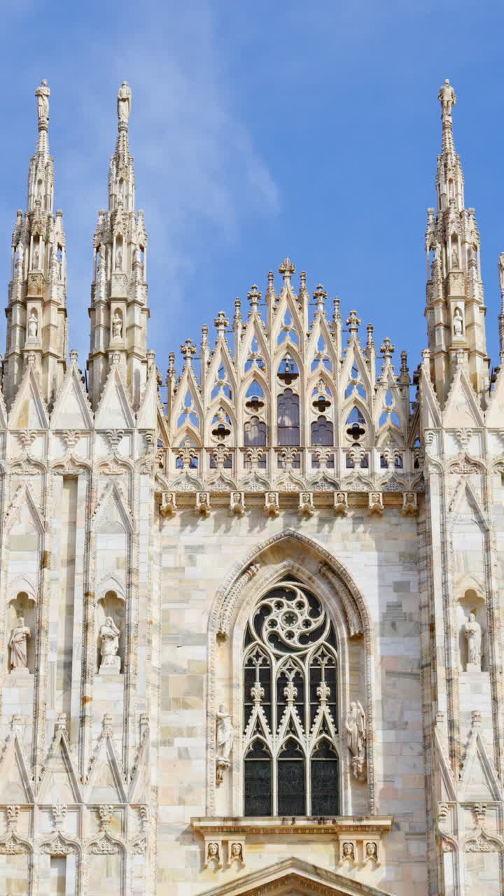 View of the Milan Cathedral in Italy over a cloudy sky in daylight. Vertical