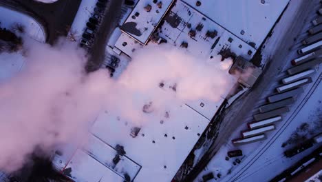 a top-down aerial shot of the steaming factory in winter