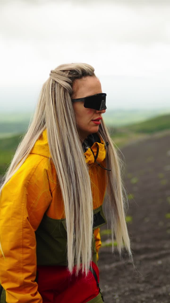 Donna avventurosa con capelli biondi che fa escursioni su un sentiero di montagna