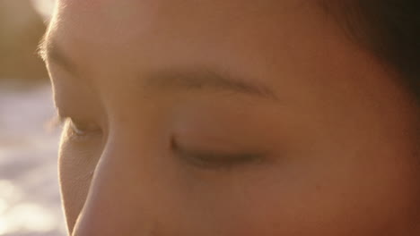 close up portrait of beautiful asian woman enjoying seaside at sunset exploring spirituality looking up praying contemplating journey relaxing on beach