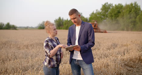 Agricultor-Examinando-Cultivos-De-Trigo-En-Las-Manos-Mientras-Usa-La-Tableta-Digital