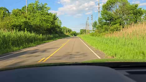 a beautiful sunny day drive down a rural road surrounded by lush greenery and trees