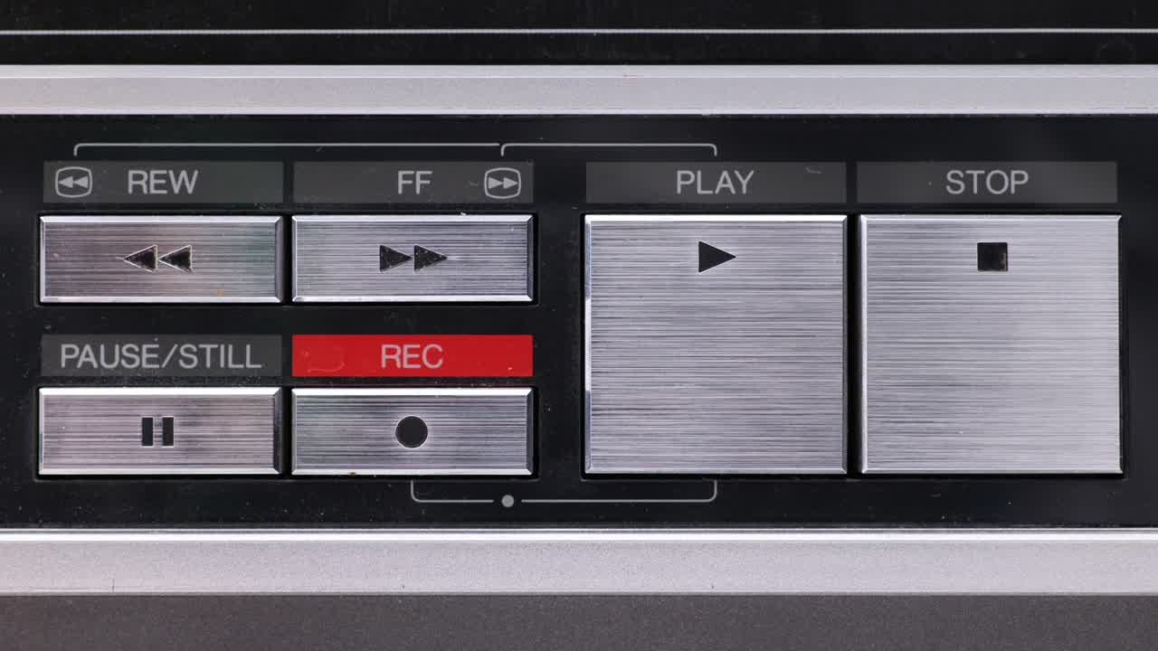 Extreme close up of buttons on an old antique or vintage VCR Pushing Fast forward