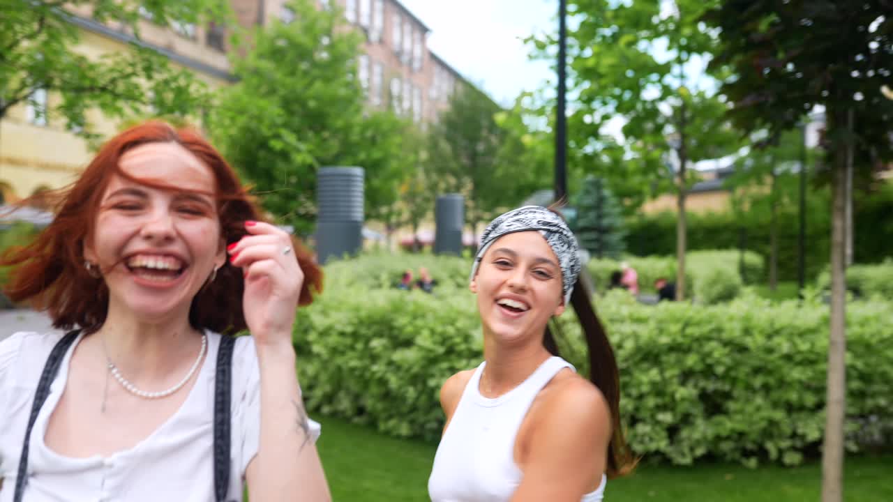 두 명의 행복한 젊은 여성들이 도시 공원에서 시간을 즐기고 있습니다.