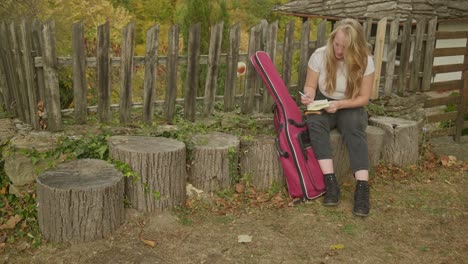 Woman-songwriter-sits-writes-lyrics-inspired-autumnal-rustic-charm-scene