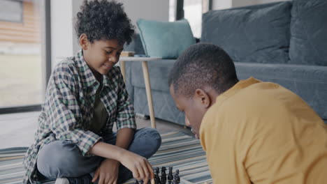 father and son playing chess at home