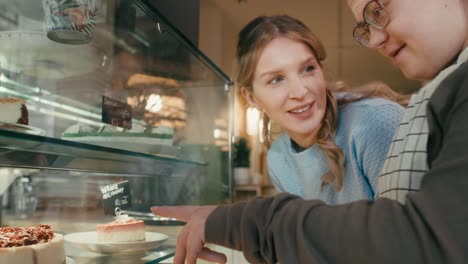 zoom de la chica del síndrome de down aconsejando al cliente qué pastel elegir