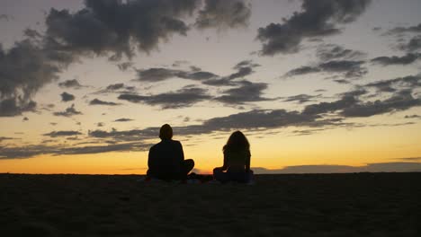 meditating couple on a beach