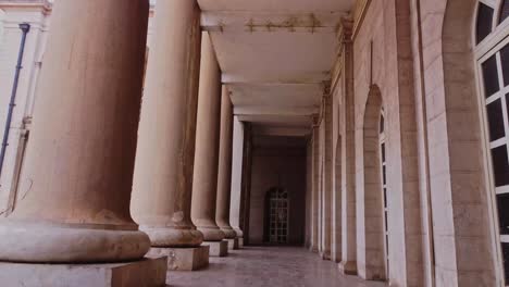 low angle dolly in of an imposing hallway with old columns at mapo hall in ibadan, nigeria