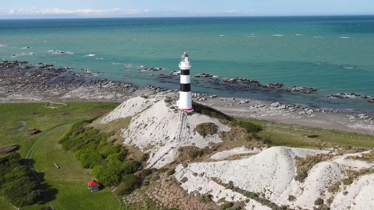 Faro di Cape Campbell che si affaccia su una natura selvaggia costiera incontaminata sotto la luce intensa del sole, Nuova Zelanda